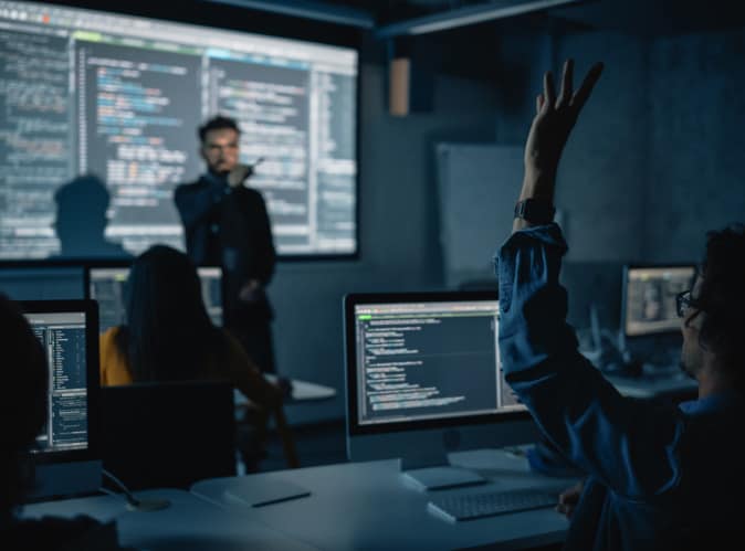 man raising his hand in coding class
